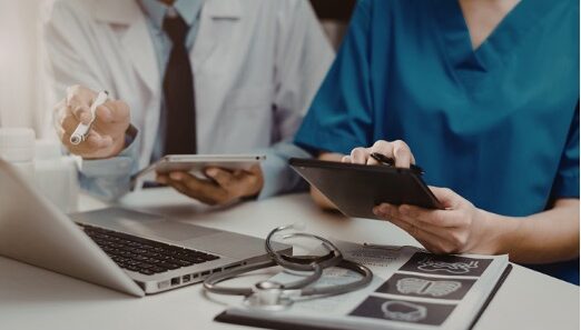 Female nurse practitioner reviewing chart with male physician following HIPAA requirements