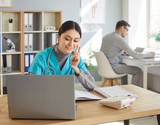 Female nurse practitioner scheduling patients and male nurse practitioner working at desk.