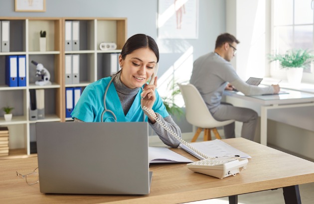 Female nurse practitioner scheduling patients and male nurse practitioner working at desk.