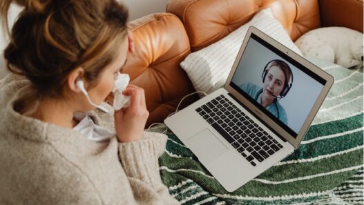 female patient using telehealth video call with female nurse on laptop from home