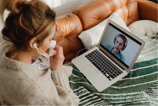 female patient using telehealth video call with female nurse on laptop from home