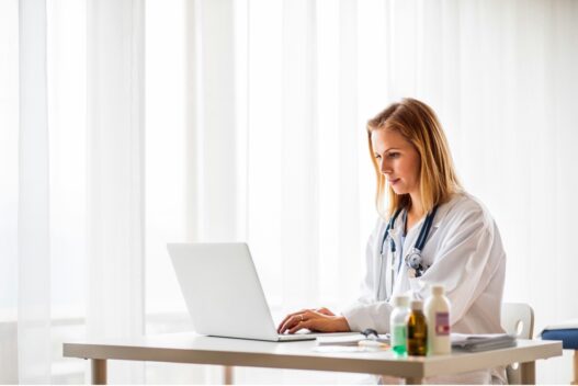 Nurse practitioner calculating the cost to open an NP practice at her desk