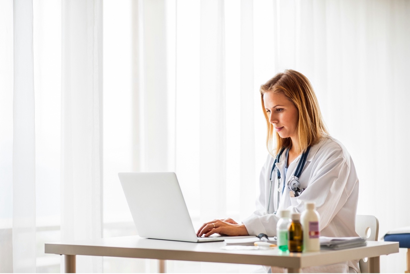 Nurse practitioner calculating the cost to open an NP practice at her desk