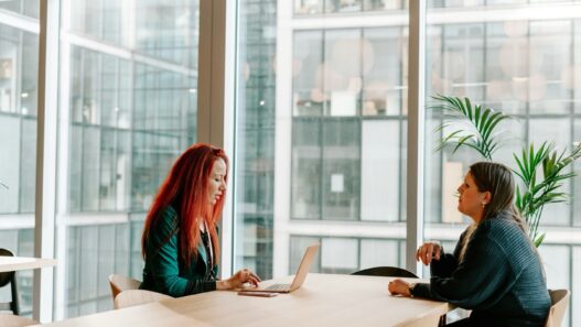 Two nurse practitioners discussing a solo or partner practice decision at a desk