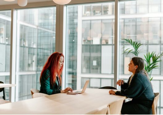 Two nurse practitioners discussing a solo or partner practice decision at a desk