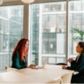 Two nurse practitioners discussing a solo or partner practice decision at a desk